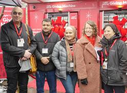 IRC Washington staff and community member pictured in front the red Light the World Giving Machines