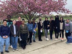 A group of students standing in front of a tree