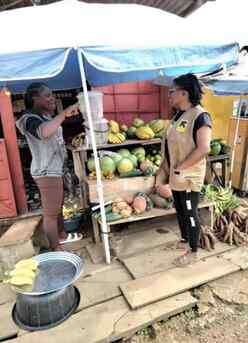 Mercy stands with an IRC staff in front of her shop. 