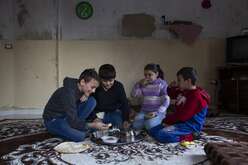 A group of children in Lebanon huddled together, sharing a meal