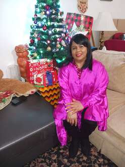 Client sitting on a couch beside a Christmas tree