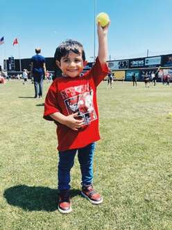 young child holding up a ball