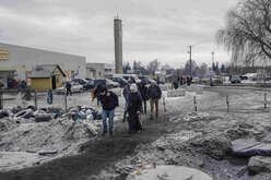 Refugees arrive at Medyka border crossing point, Poland. They are wearing warm clothing, around them, snow lies on the ground. 