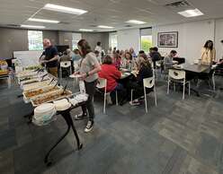 Volunteers gather to enjoy a buffet donated by Mazza Cafe at the IRC in Utah office.
