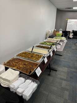 A variety of foods arranged on tables in a buffet donated by Mazza Cafe.