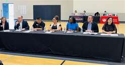 Group of individuals sitting behind a table
