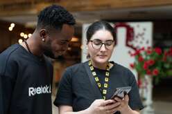 Staff and client looking at a phone together.