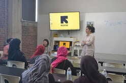 Group of women attending a workshop led by a facilitator in a classroom setting.