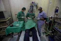 Three surgeons operating on a patient