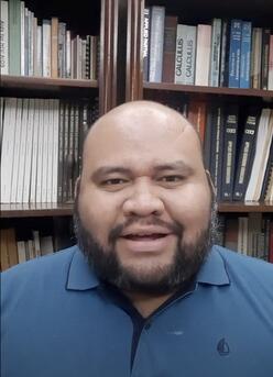 Alexander, specialist in education, IRC Venezuela talking to camera in the background are books