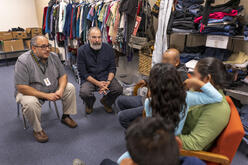 Mandy Patinkin speaks with a family who fled from Mexico at IRC welcome center in Phoenix, Arizona