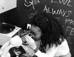 Torbertha Torber looks into a microscope