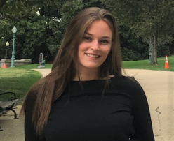 Americorps Employee smiling on the sidewalk outside.