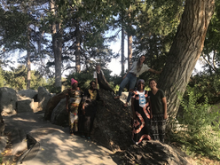 Six women smile for the camera in the woods while on a hike organized by the IRC in Salt Lake City's Women's Health & Healing Group