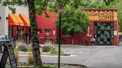 Street view of a red coffee shop and entrance into the parking lot.