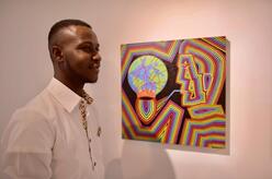 Adama Coulibaly in front of a piece, “Save Thy Terre,” that sold after The Onishi Project exhibition.