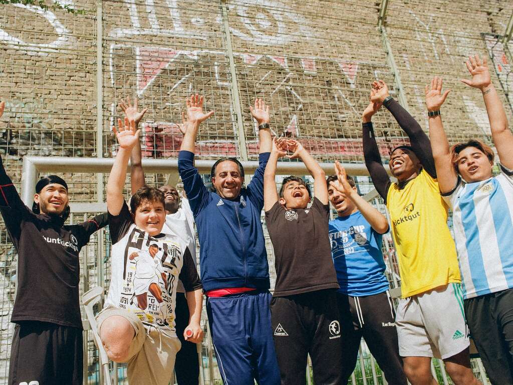 Eine Gruppe von neun Fußballspielern jubelt.