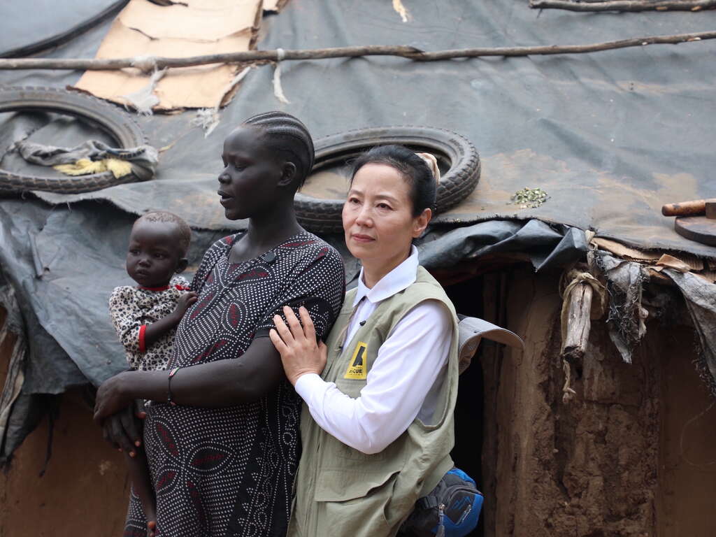 국제구조위원회 오민애 홍보대사가 한 고객의 집을 방문하여 고객을 안아주고 있습니다. 