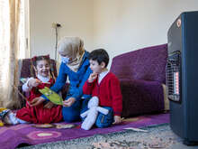 Sulaima och hennes två barn Mira och Jawad sitter i deras hem och genomför en pedagogisk aktivitet.