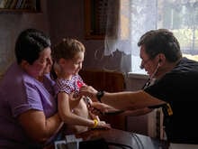 En RESCUE anställd gör en medicinsk undersökning på en flicka.