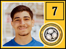 Ein junger Mann mit kurzem, dunklem Haar und einem leichten Bart trägt ein blaues T-Shirt und lächelt in die Kamera.