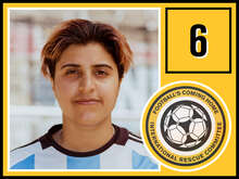 Eine junge Frau mit kurzen Haaren in einem Fußballtrikot blickt in die Kamera.