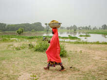 Faiza Habibu carrying bowl of fish on her head