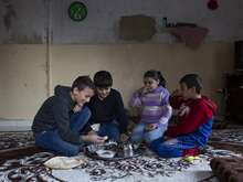 A group of children in Lebanon huddled together, sharing a meal