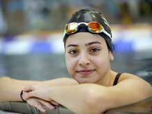 수영선수 유스라가 카메라를 보고 웃고 있습니다. 