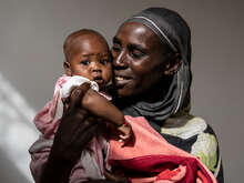 En mamma håller sitt barn i sin famn på en klinik i Tchad.