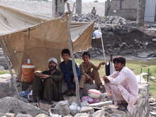 홍수피해를 입은 사람들이 폐허 속에 앉아있습니다.