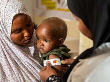 A woman holding a baby and smiling at him