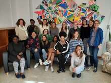 Gruppenfoto vor bunter Wandmalerei in kreativem, modernem Raum