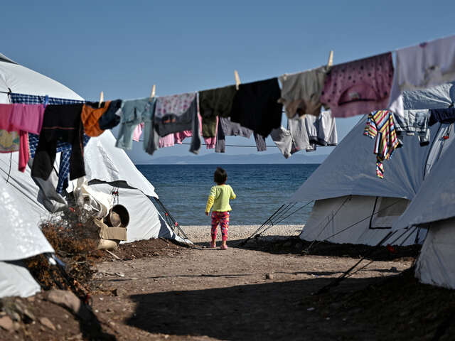 En liten flicka går bland tälten på flyktinglägret i Lesbos, Grekland.