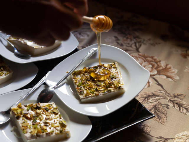  Huthaifa, 32, pours some of his honey on sweets that his wife had made at his aparment.