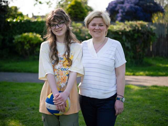 Margarita and her daughter look into the camera smiling