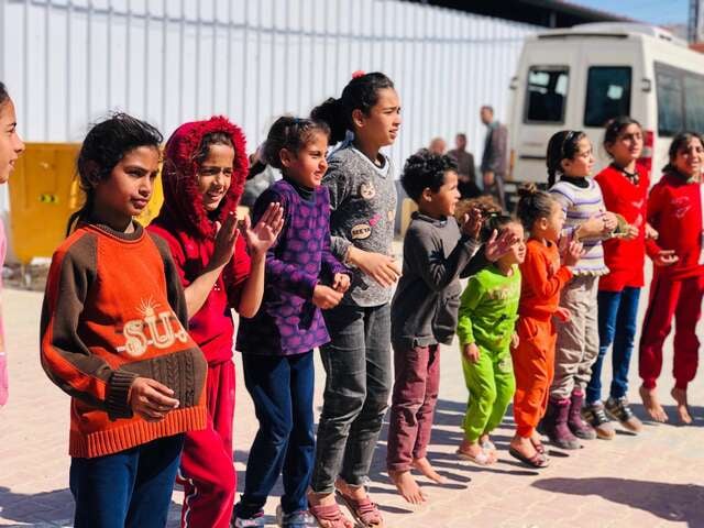 Barn står i en ring och deltar i aktiviteter som RESCUE:s partnerorganisation Nafs anordnar i Gaza.