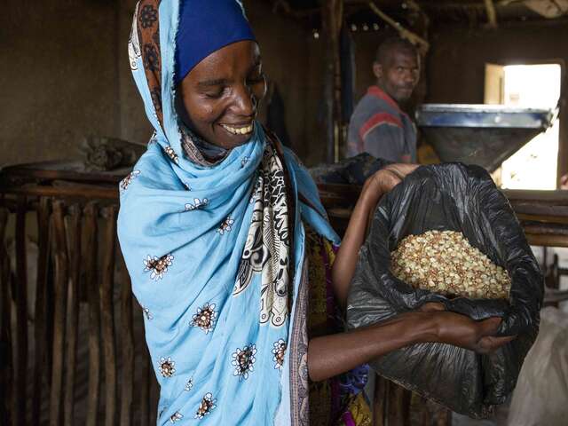 Frau zeigt gemahlene Samen