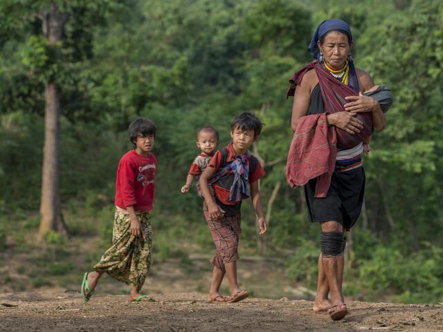 A woman and her children walk to receive vaccinations and medicines from the health team.