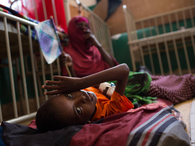 A young boy lies on a cot in the Mogadishu hospital where he is being treated for malnutrition