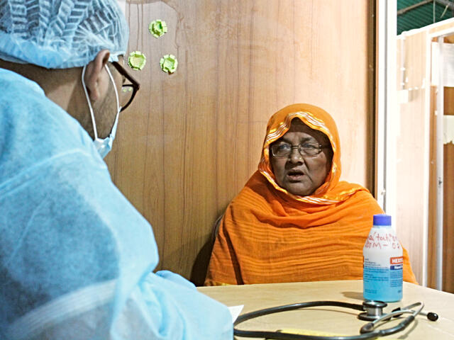 At the IRC health center in Cox's Bazar, Dr. Muhaiminur speaks with Ambia, a 60-year-old refugee