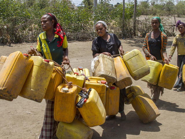 Women carry jerry cans