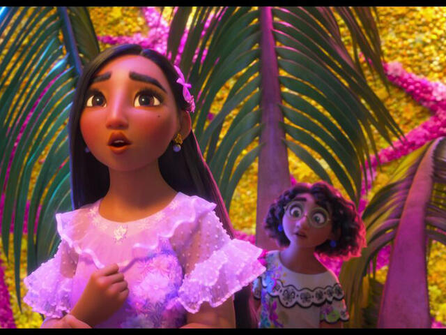 In a room with pink and purple plans, Isabela sings while Mirabel looks on.