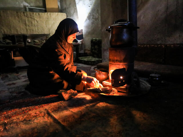 A Syrian woman cooks in her underground shelter in Eastern Ghouta.