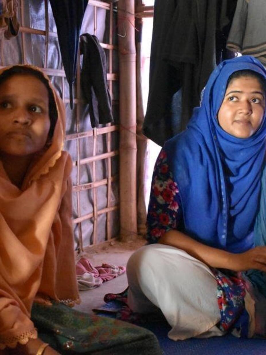 Two women sitting in a bamboo hut