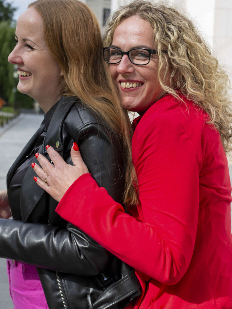 Zwei Frauen umarmen sich in der Stadt.