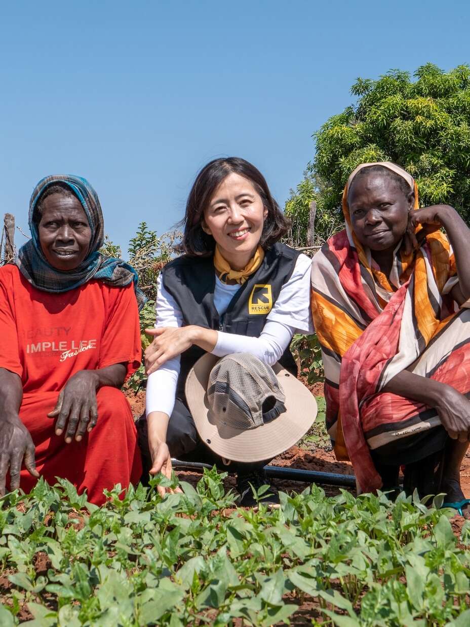 이은영 대표가 남수단 고객들과 함께 수확물 앞에서 활짝 웃고 있습니다.