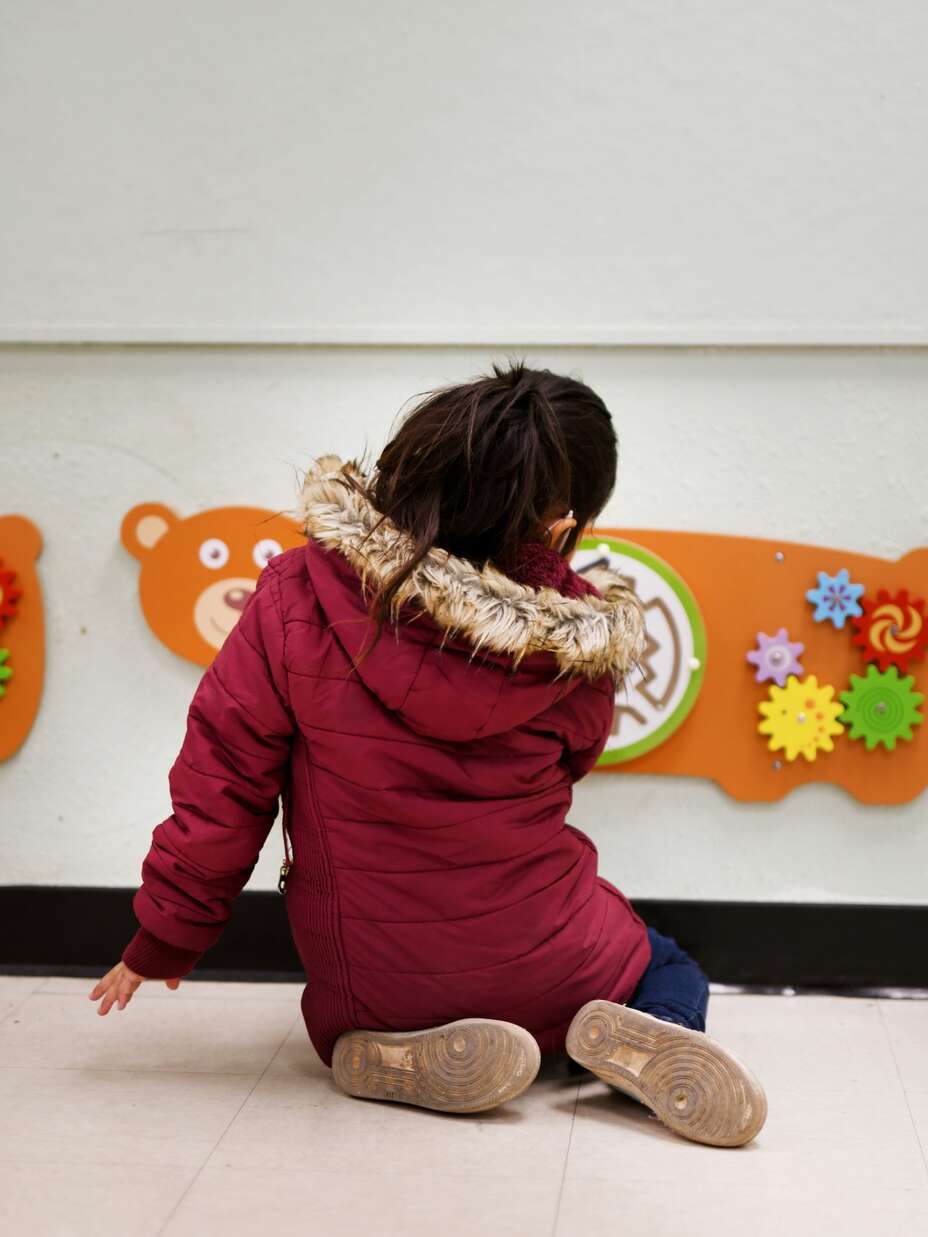 A young unaccompanied child paints at an IRC safe space.