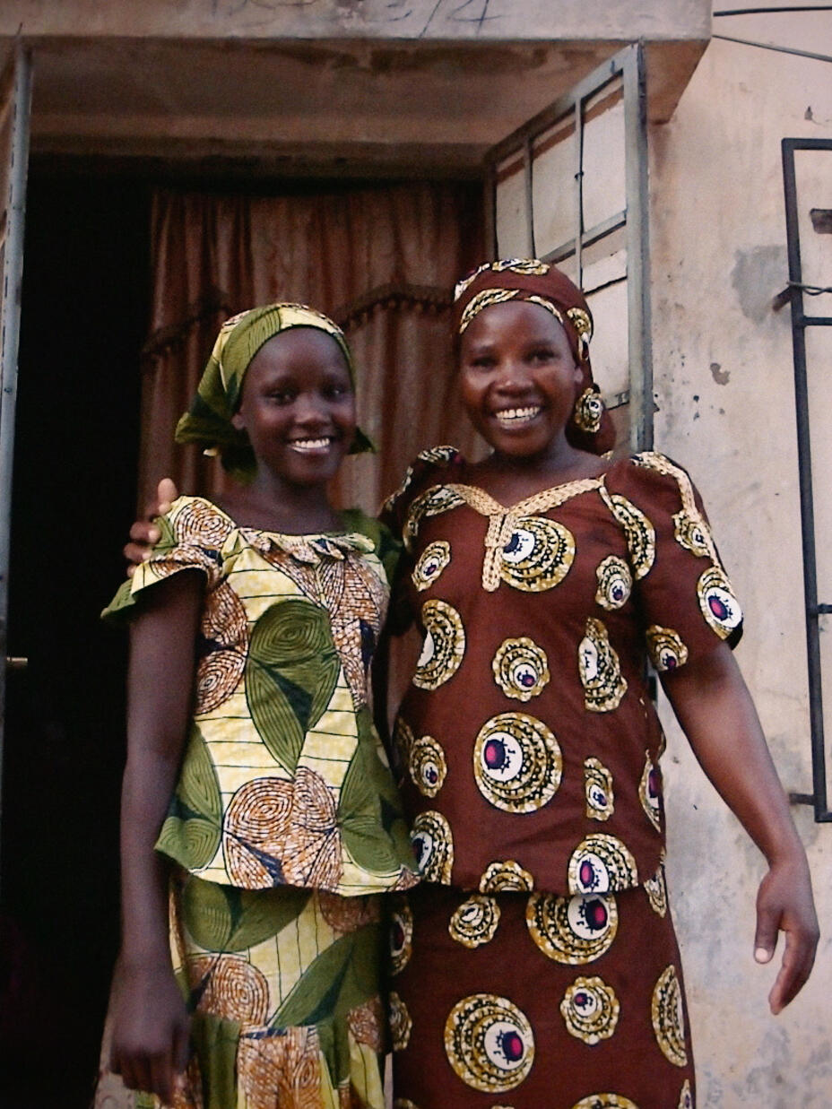 Ruth stands with her Mum outside her home in North-East Nigeria.
