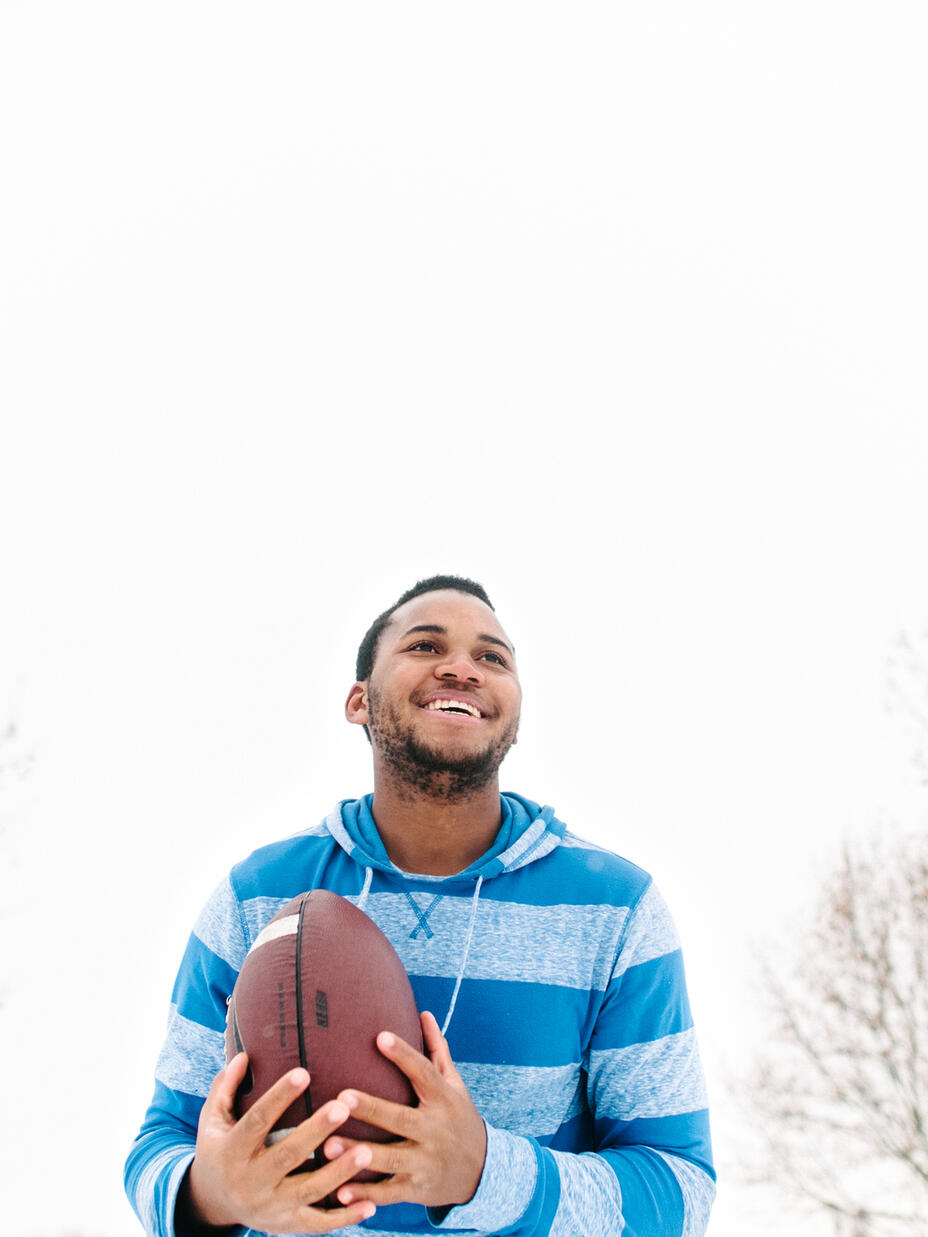 George Ngalamulume outside his home, holding a football